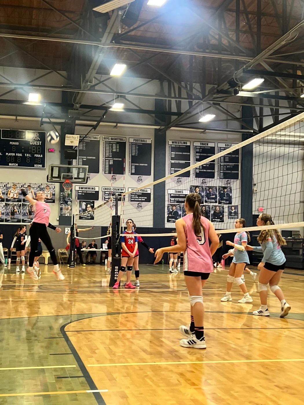 Young players practicing at the net in a school gym