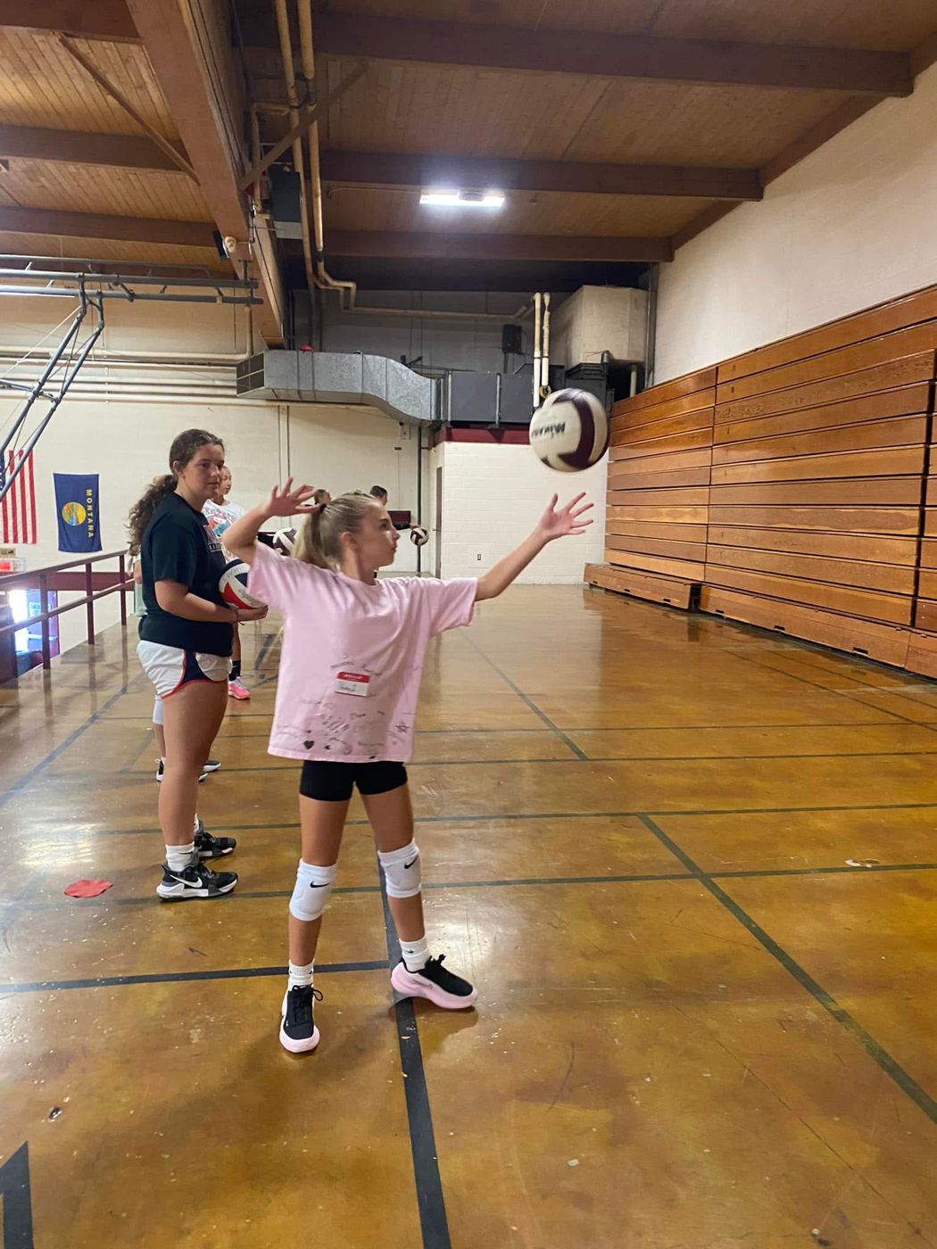 A coach tossing a ball to a young player during practice